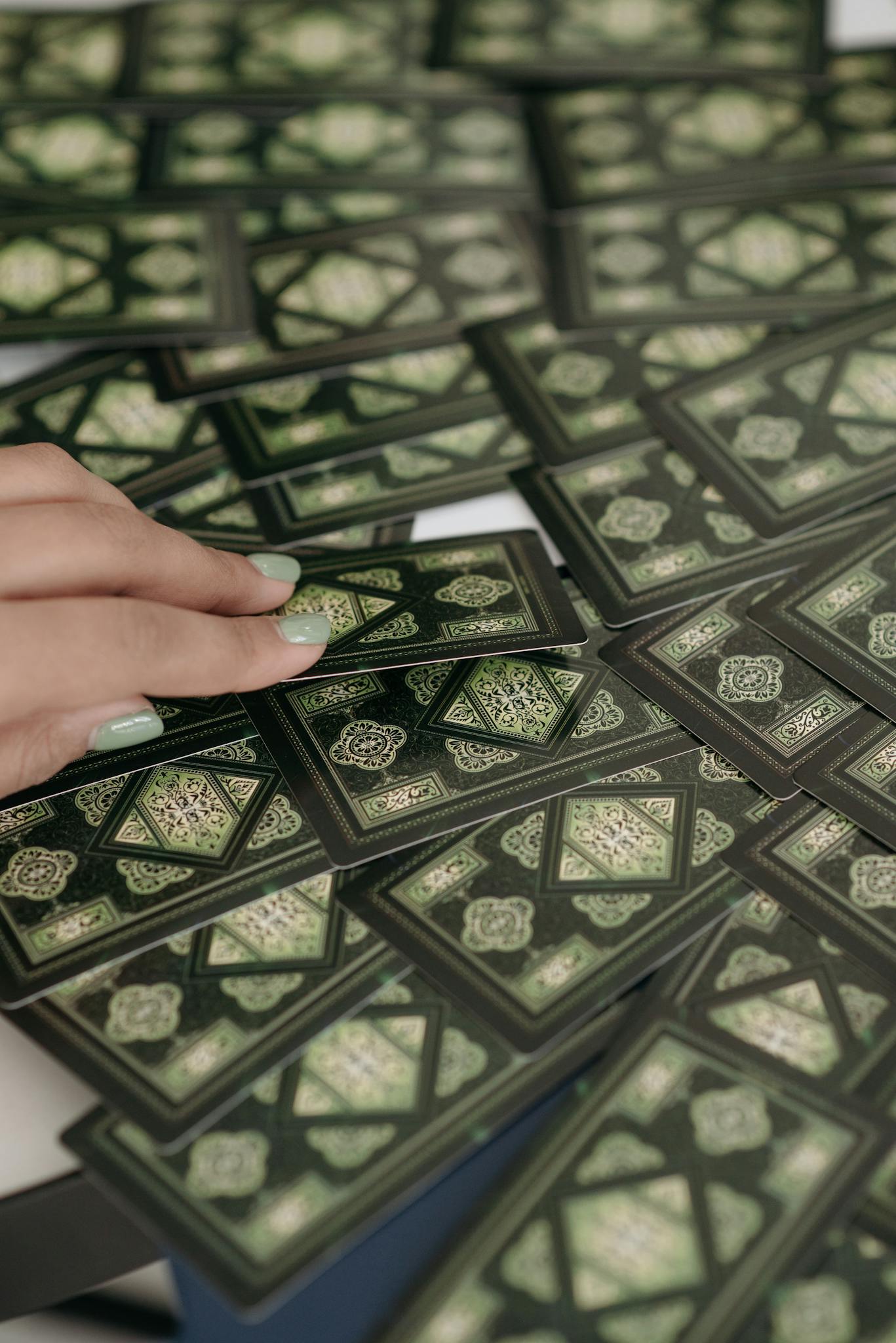 A hand selecting a tarot card from a shuffled deck, symbolizing mystery and fortune-telling.